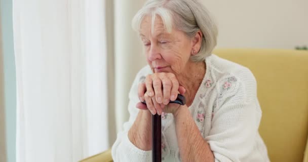 Starší žena, hůl a myšlení na domácí pohovce pamatovat si vzpomínky a relaxovat v důchodu. Vážná a smutná starší osoba nebo stará dáma se zdravotním postižením v pečovatelském zařízení s Alzheimerem a depresí. - Záběry, video