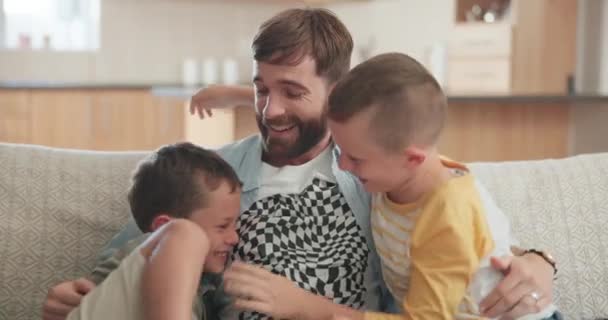 Happy, playful and funny with father and children on sofa for bonding, affectionate and free time. Happiness, relax and care with man and kids in living room of family home for embrace and love. - Footage, Video