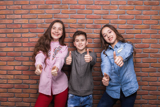 Set di bambini adolescenti multirazziali giocosi in abbigliamento casual alla moda che si divertono mentre si trovano su uno sfondo luminoso in studio
 - Foto, immagini