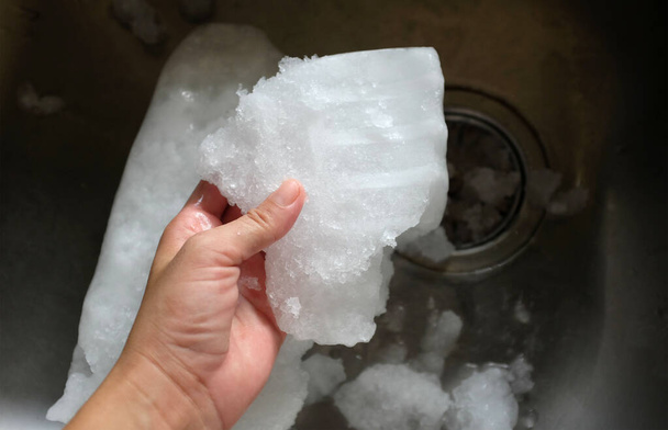 Ghiaccio dal freezer nel palmo della mano asiatico uomo primo piano - Foto, immagini