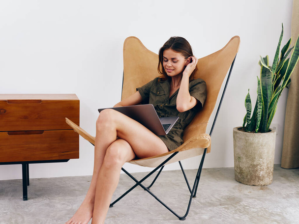Mujer freelancer sentado en silla con el trabajo del ordenador portátil en casa sonrisa, moderno y elegante estilo de vida escandinavo interior, espacio de copia. Foto de alta calidad - Foto, imagen