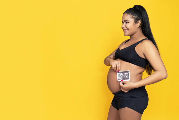 Sarı arka planda hamile Afrikalı Amerikalı kadın.. - Fotoğraf, Görsel