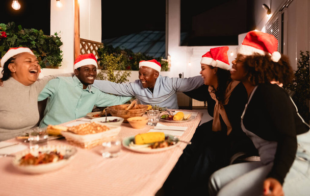 Boldog afrikai család ünneplik a karácsonyi ünnepeket együtt vacsoráznak otthon - Fotó, kép