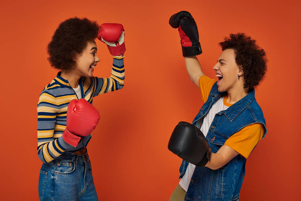 glücklich afrikanisch-amerikanische Geschwister in Boxhandschuhen gemeinsam Spaß auf orangefarbenem Hintergrund, Familie - Foto, Bild