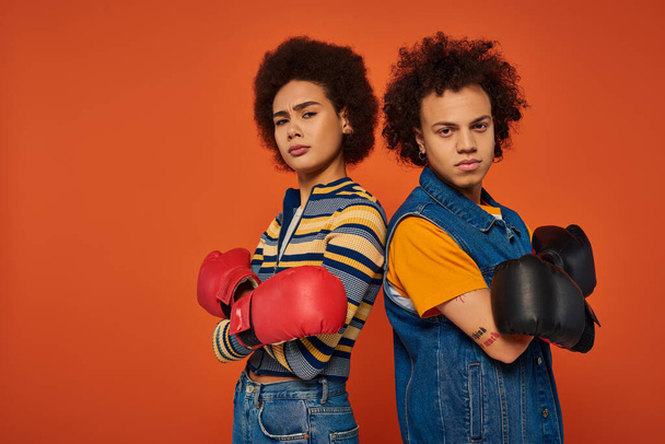 sportovní afroameričtí sourozenci v boxerských rukavicích baví společně na oranžovém pozadí, rodina - Fotografie, Obrázek