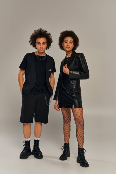 attractive trendy african american siblings in stylish black outfits posing actively together - Fotografie, Obrázek