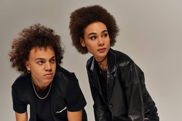 portrét mladých afrických amerických sourozenců v módních černých šatech pózujících na šedém pozadí - Fotografie, Obrázek