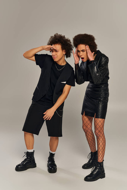 emocjonalnie zdezorientowane afrykańskie rodzeństwo w czarnych ubraniach wyglądające na zdezorientowane na szarym tle - Zdjęcie, obraz