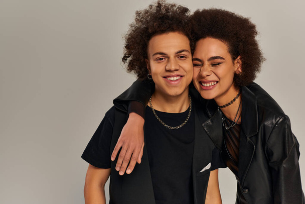 positive stylish african american brother and sister in trendy outfits hugging and smiling happily - Photo, Image