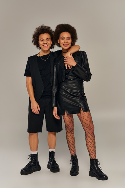 joyeux frère et sœur afro-américaine élégant dans des tenues à la mode étreignant et souriant joyeusement - Photo, image