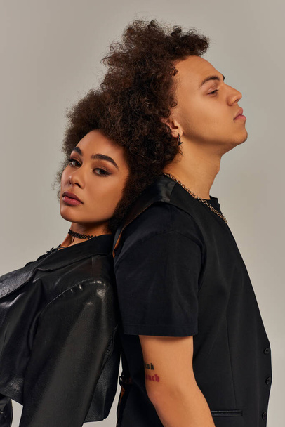 trendige junge afrikanisch-amerikanische Bruder und Schwester in stilvollen Klamotten posieren zusammen vor grauem Hintergrund - Foto, Bild