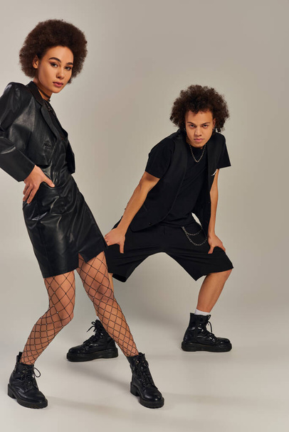 young african american brother and sister in black outfit posing together on gray backdrop, family - Photo, Image