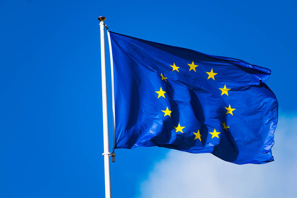 Europe flag fluttering with strong wind and blue sky, blue flag with yellow stars forming a circle - Photo, Image