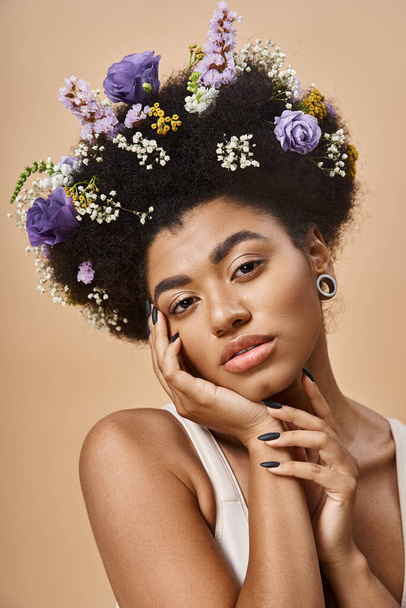 portrait of charming african american woman with colorful flowers in hair looking away on beige - Photo, Image