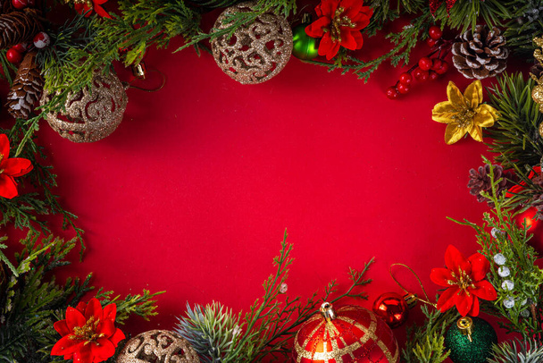 Hochfarbiger Weihnachts- und Neujahrshintergrund mit Tannenzweigen, Tanne, Christbaumkugeln, Dekor und Weihnachtsblumen, Kopierraum von oben - Foto, Bild