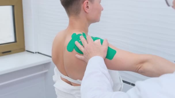 Een orthopedisch traumatoloog onderzoekt een vrouwelijke patiënt om letsel, pijn, mobiliteit te bepalen en de diagnose van behandeling in de schouder, arm, elleboog en pols gebieden. - Video