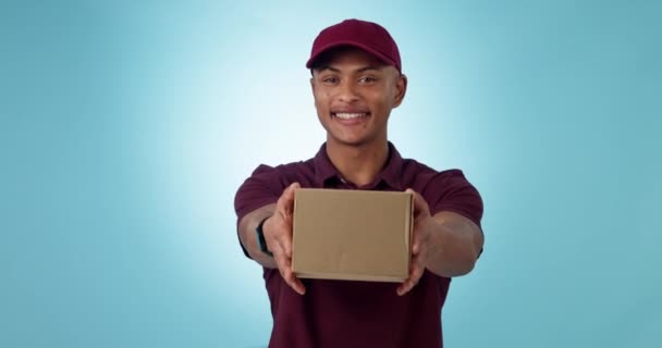 Delivery, studio and happy man giving box for logistics work, courier shipping or commercial post service. Portrait, package distribution and person offer order, parcel or goods on blue background. - Footage, Video