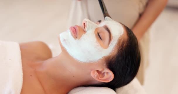 Skincare, beauty and spa face mask with woman facial at a wellness, health and salon. Relax, luxury and and girl resting while beautician hands apply exfoliation, peeling and hydration skin product. - Footage, Video