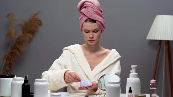 Hautpflege. Anti-Aging-Behandlung. Junge Frau, die Kollagen-Hydrogelpflaster aufträgt, sitzt nach der Dusche im häuslichen Bereich mit Spiegel. Kopierraum - Filmmaterial, Video