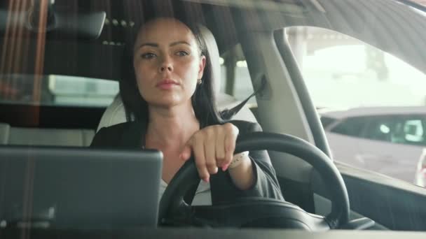 Mladá žena se dívá na silnici, projíždí městem a ukazuje chodci gesto. Bezpečnost jízdy, doprava, výlet, obchodní koncepce. Zpomalený pohyb - Záběry, video