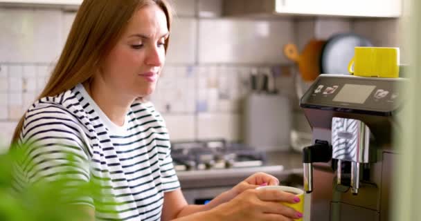 Satisfied woman drinking just brewed coffee on kitchen at morning. Attractive lady enjoying cup of coffee at home. High quality 4k footage - Footage, Video