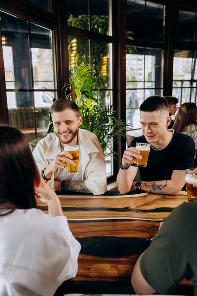 Felice gruppo di amici che bevono e bevono con birra e cocktail al ristorante del bar della birreria - Foto, immagini