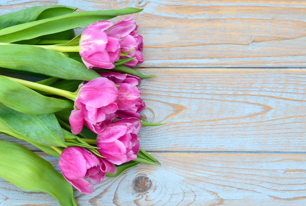 Background of Pink  purple tulips with empty space of old blue grey used shelves wood for your own text or photo - Foto, imagen