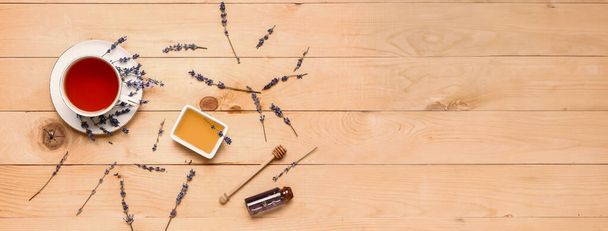 Mísa sladké levandulový med a šálek čaje na dřevěném pozadí s prostorem pro text, horní pohled - Fotografie, Obrázek