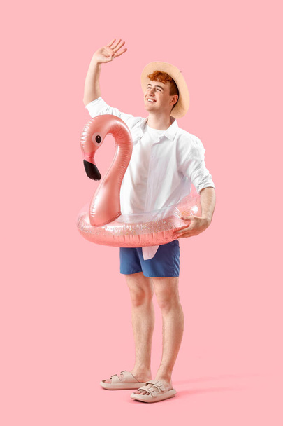 Young man with swim ring on pink background - Photo, Image