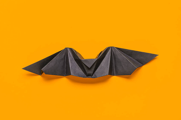 Zwarte origami vleermuis op oranje achtergrond - Foto, afbeelding