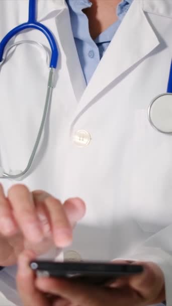 jeune femme médecin avec stéthoscope en utilisant un smartphone  - Séquence, vidéo
