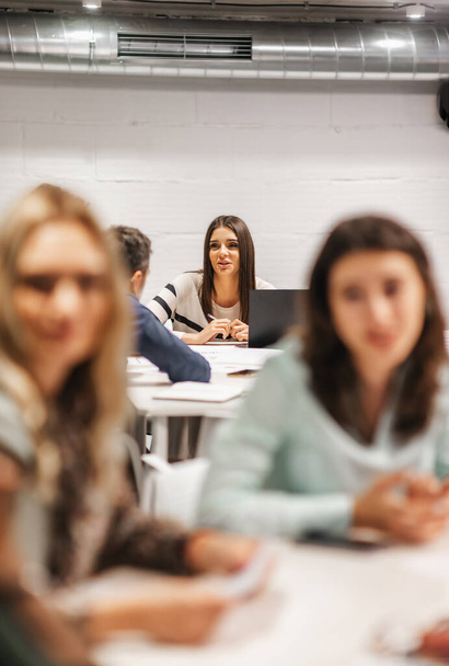 Prachtige brunette luisteren naar zakelijke adviezen door haar middelbare leeftijd ervaren teamleider tijdens de vergadering aan tafel - Foto, afbeelding