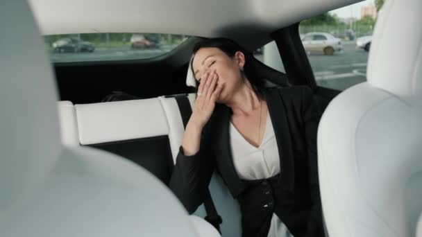Donna d'affari stanca di riposare mentre dorme sul sedile posteriore, sbadigliando durante il viaggio in auto. Trasporto, viaggio, business concept. Rallentatore - Filmati, video
