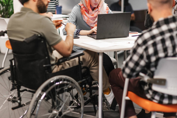 Multiculturális emberek dolgoznak a Google környezetben a munkahelyen. Nő hidzsáb dolgozik lap tetején. - Fotó, kép