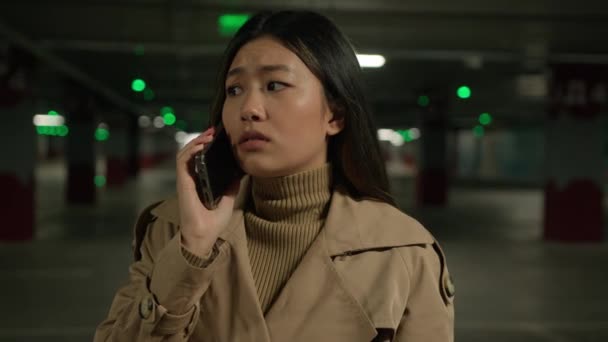Upset sad Asian woman chinese korean japanese businesswoman talking mobile phone alone in car parking call taxi disappointed ethnic girl talk smartphone quarrel worry bad news unpleasant conversation - Footage, Video