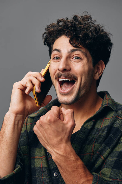 Studio man mooi knap een stijlvolle telefoon glimlach levensstijl geïsoleerd hoofd wit hispanic aantrekkelijke technologie grijs shirt slimme achtergrond gelukkig closeup portret - Foto, afbeelding