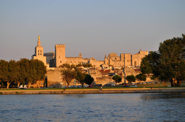 Palácio Papal na cidade de Avignon, França iluminado pelo pôr-do-sol com o dique do rio Reno. - Foto, Imagem