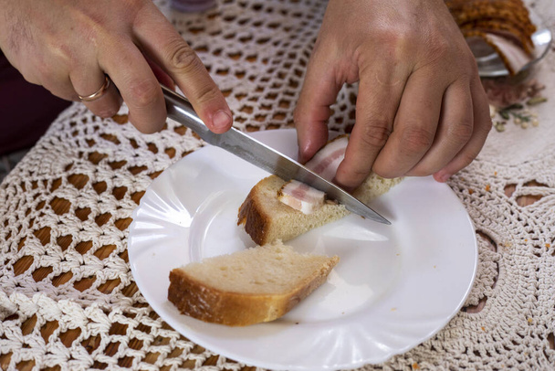 ut un pezzo di pane con pancetta su un piatto bianco.snack - Foto, immagini