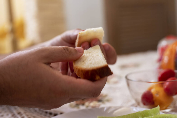  muž drží kousky krájeného chleba v rukou před snídaní - Fotografie, Obrázek