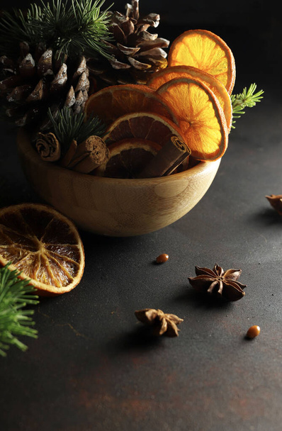 Composizioni natalizie con fette di arancia secca, cannella e anice isolate su fondo nero. Natale e periodo festivo. - Foto, immagini