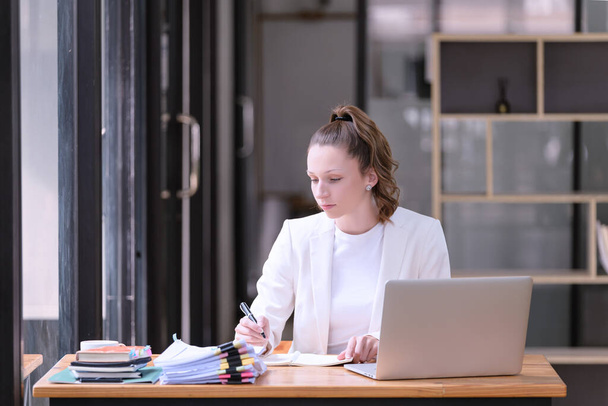 Bizneswoman pracująca przed laptopem w biurze. Przypadkowa i udana koncepcja biznesu - Zdjęcie, obraz