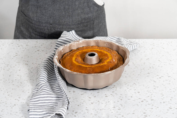 Refroidissement gâteau bundt vanille simple fraîchement cuit sur un comptoir de cuisine. - Photo, image