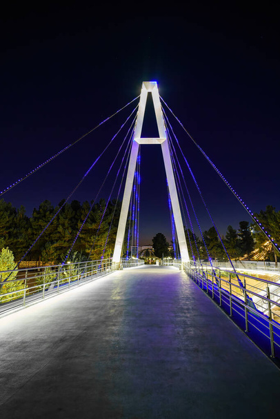 Modern footbridge with steel cables across the Anhor canal in Navruz park with illumination lights at nighttime, Uzbekistan, Tashkent. - Photo, Image