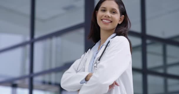 Medical, woman and doctor with smile and arms crossed for trust, medicine or cardiology at hospital or clinic. Healthcare, professional and employee and happy for service, career or health support. - Footage, Video