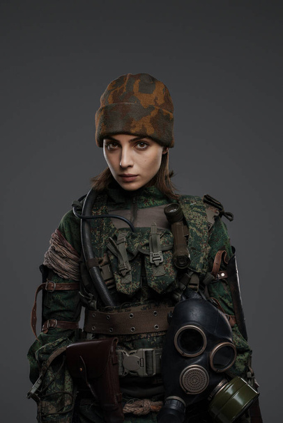 Храбрая женщина-солдат с раненой рукой в военной форме символизирует сопротивление в ближневосточном конфликте, на сером фоне - Фото, изображение