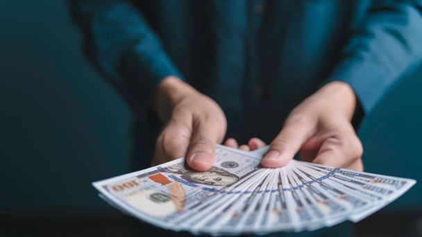obchodník drží dolarové bankovky v ruce finanční úspěch a bohatství dobré finanční řízení. - Fotografie, Obrázek