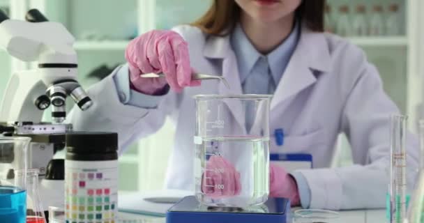 Laboratóriumi tudós dobja kálium-permanganát oldott vízben. Hígítsuk fel a kálium-permanganátot a megfelelő konzisztencia érdekében - Felvétel, videó