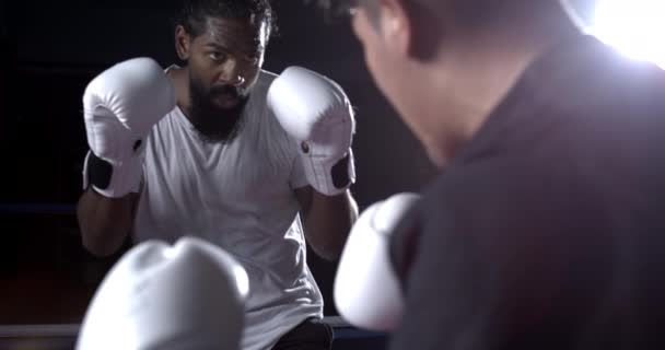 Dos luchadores enfrentados dentro del ring de boxeo, rivales mirando cara a cara usando guantes. Opositores luchando en cámara lenta en rampa de velocidad a 800 fps - Imágenes, Vídeo
