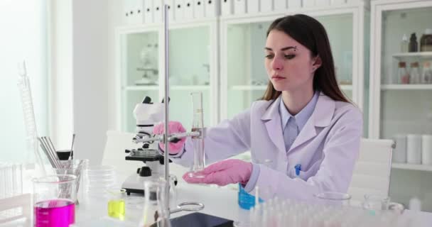 Επιστήμονας βιολόγος βοηθός εργαστηρίου φοιτητής καθορίζει δοκιμαστικό σωλήνα σε στάση στο εργαστήριο. Εργαστηριακός εξοπλισμός - Πλάνα, βίντεο