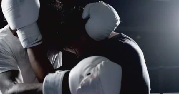 Combatientes enganchados previniendo golpes, batalla en cámara lenta en el anillo de boxeo dramáticamente iluminado - Imágenes, Vídeo